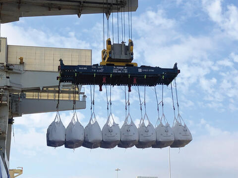 huge bags of bulk sugar hanging from an offloading crane