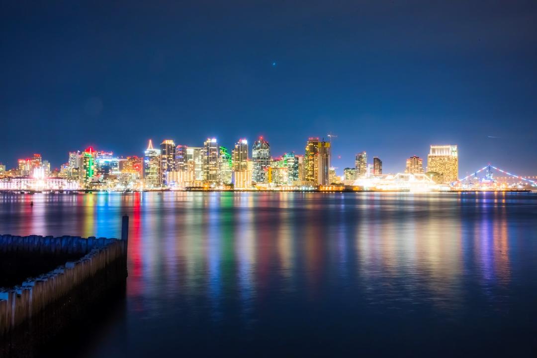 a nighttime view from Harbor Island looking towards the lit-up skyline of downtown San Diego