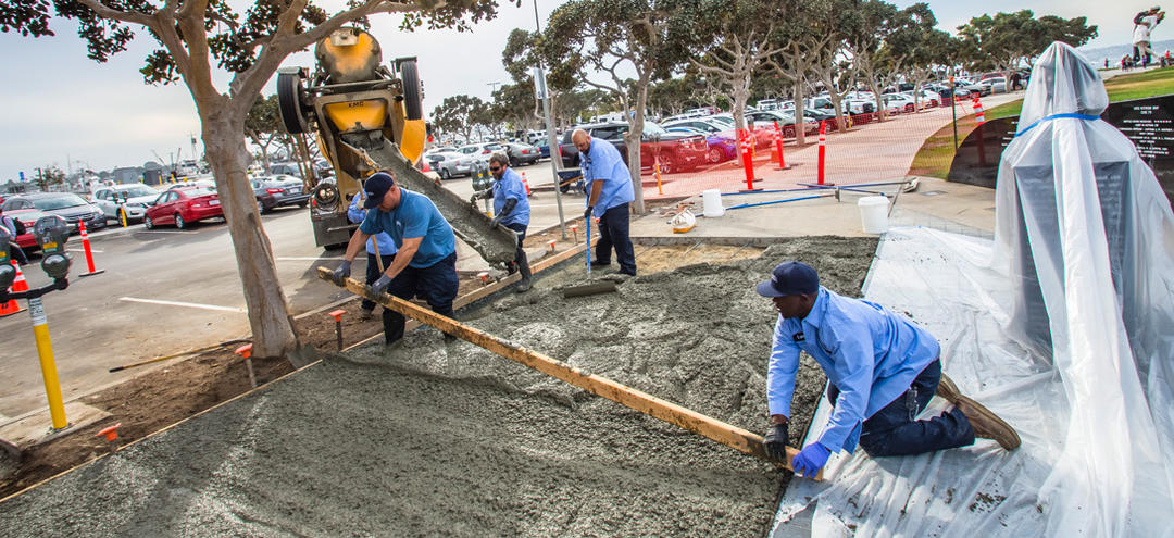 Workers putting down a concrete sidewalk