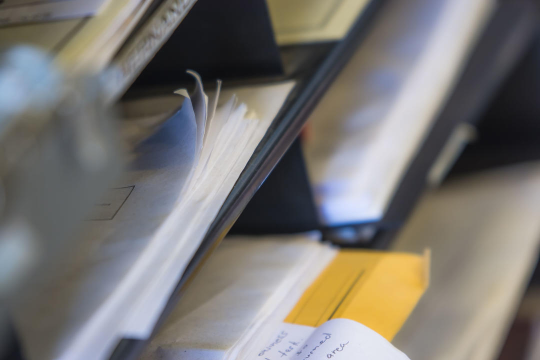 papers stacked on a desk in an office