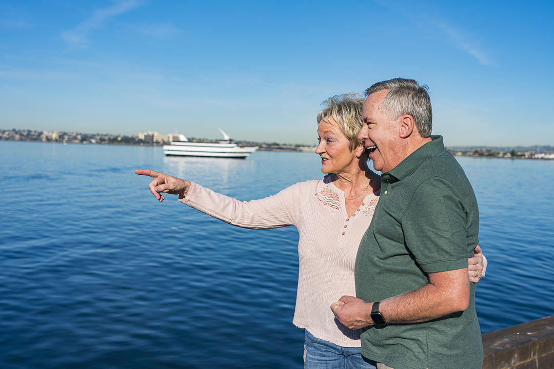 a man and a woman pointing at the sea