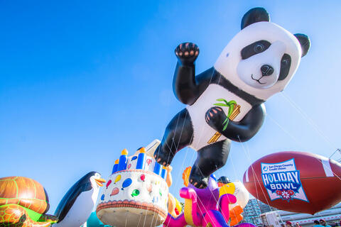A giant panda balloon and a giant football balloon.
