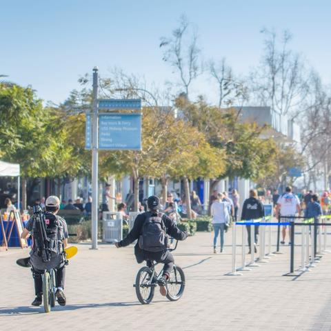 People enjoy the sun, trees and ride bikes along the Embarcadero at Broadway Plaza Park