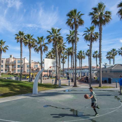 Kid playing on the basketball court at Dunes Park at the Port of San Diego
