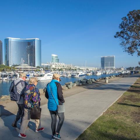 A group of people walking along Embarcadero Marina Park North at the Port of San Diego
