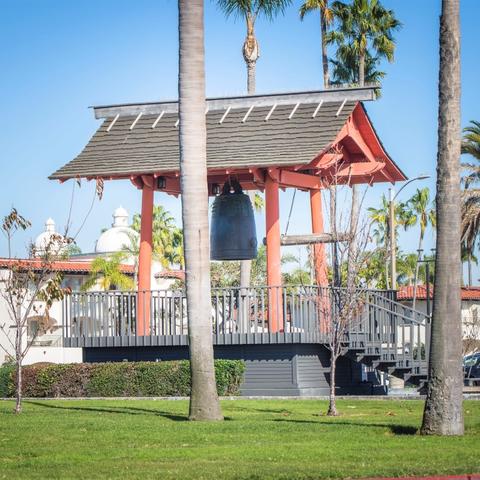 Yokohama Friendship Bell surrounded by trees and grass at Shelter Island Shoreline Park at the Port of San Diego