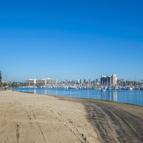 Sand beach and sparking blue water under bright blue skies at Spanish Landing Park at the Port of San Diego