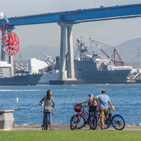 Group of cyclists in front of My Bike Sculpture by Amos Robinson at Coronado Tidelands Park at the Port of San Diego