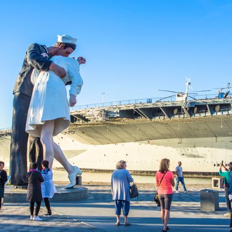 Embracing Peace painted sculpture by Seward Johnson in front of USS Midway at Tuna Harbor Park at the Port of San Diego