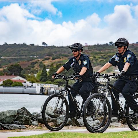 two Port of San Diego Harbor Police bike patrol in front of the bay