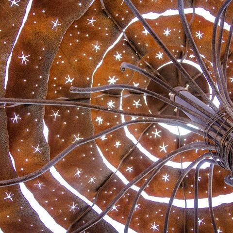 looking skyward through a rusty metal spiral